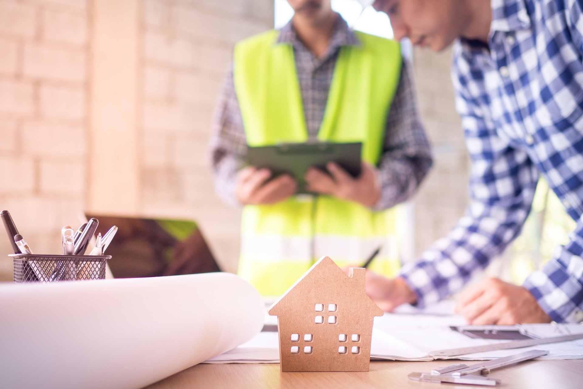 Concepto de casa de construcción. Los ingenieros y los equipos de contratistas están discutiendo actualmente el diseño de la estructura de la casa.