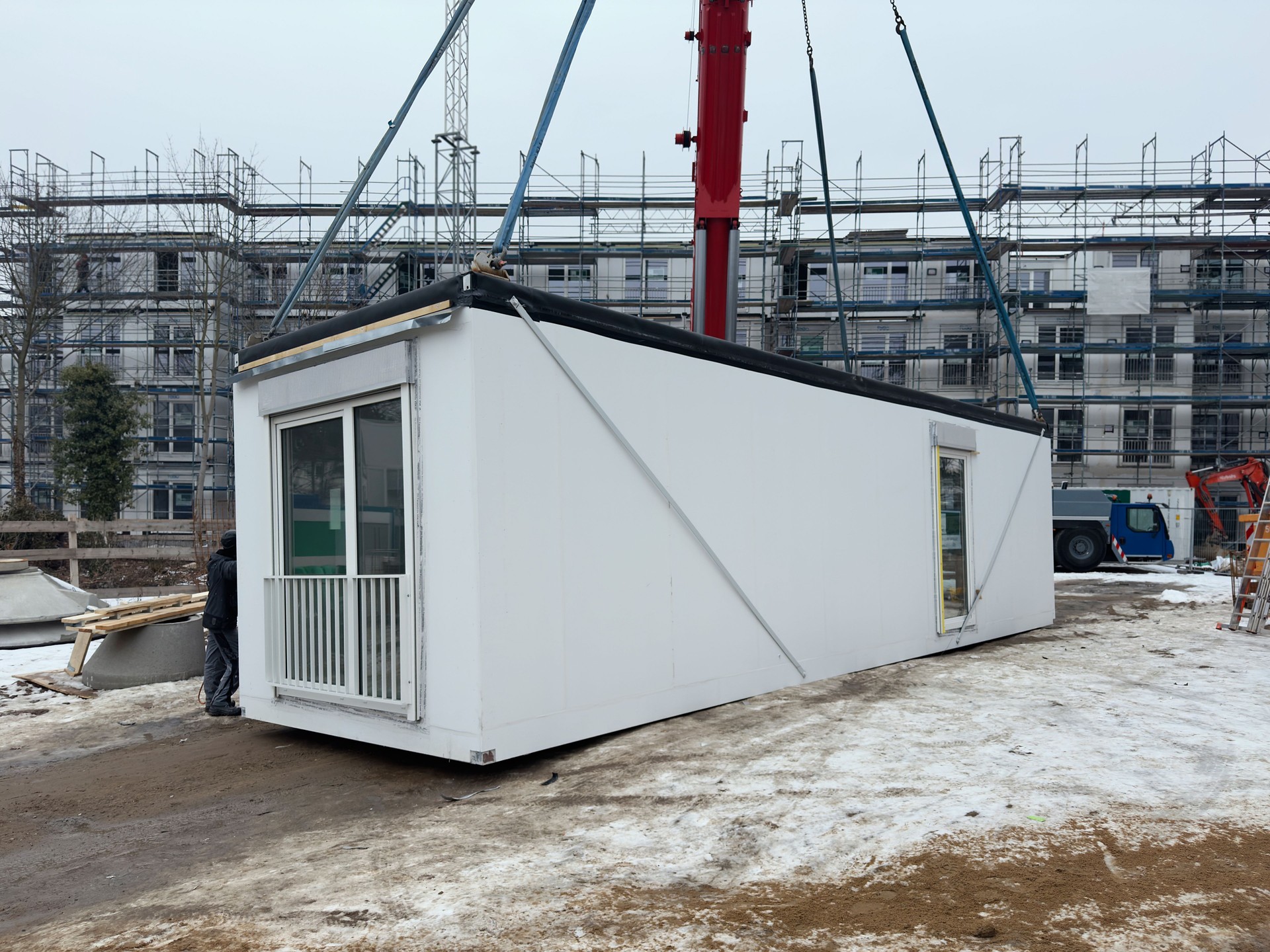 Una unidad de construcción modular prefabricada levantada por una grúa en una obra